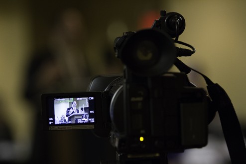 Montana Assistant Attorney General Joel Thompson through the camera lens of one of three local news outlets. All three were stationed at the front of the media section.. Photo by Eric Oravsky